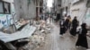 Varios palestinos caminan junto a los escombros de una casa destruida por un ataque israelí en Nuseirat, en el centro de la Franja de Gaza, el 1 de octubre de 2024.