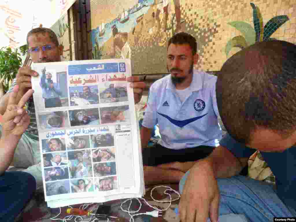 Muslim Brotherhood doctors hold up newspaper with photos of their supporters killed in a confrontation with the Egyptian military on July 8. Photo: VOA/Sharon Behn 