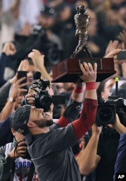 Steve Pearce de los Medias Rojas de Boston sostiene el trofeo de MVP después del Juego 5 de la Serie Mundial de béisbol contra los Dodgers de Los Angeles el domingo, 28 de octubre de 2018, en Los Ángeles. Los Medias Rojas ganaron 5-1 para ganar el juego de la serie 4 a 1. (AP Photo / Mark J. Terrill).