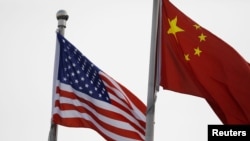 人口学家易富贤认为，中国经济永远超不过美国。图为美中国旗在一家美国公司驻北京的办公楼外飘扬。（路透社2021年1月21日资料照）