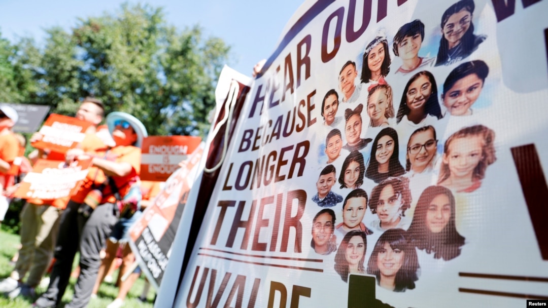 Manifestantes muestran las fotos de las víctimas de la matanza de Uvalde, en Texas, en una marcha contra las armas asalto en Washington DC, el 13 de julio de 2022. 