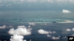 This photo taken through a window of a U.S. military plane shows China's reclamation of Mischief Reef in the South China Sea, May 11, 2015.