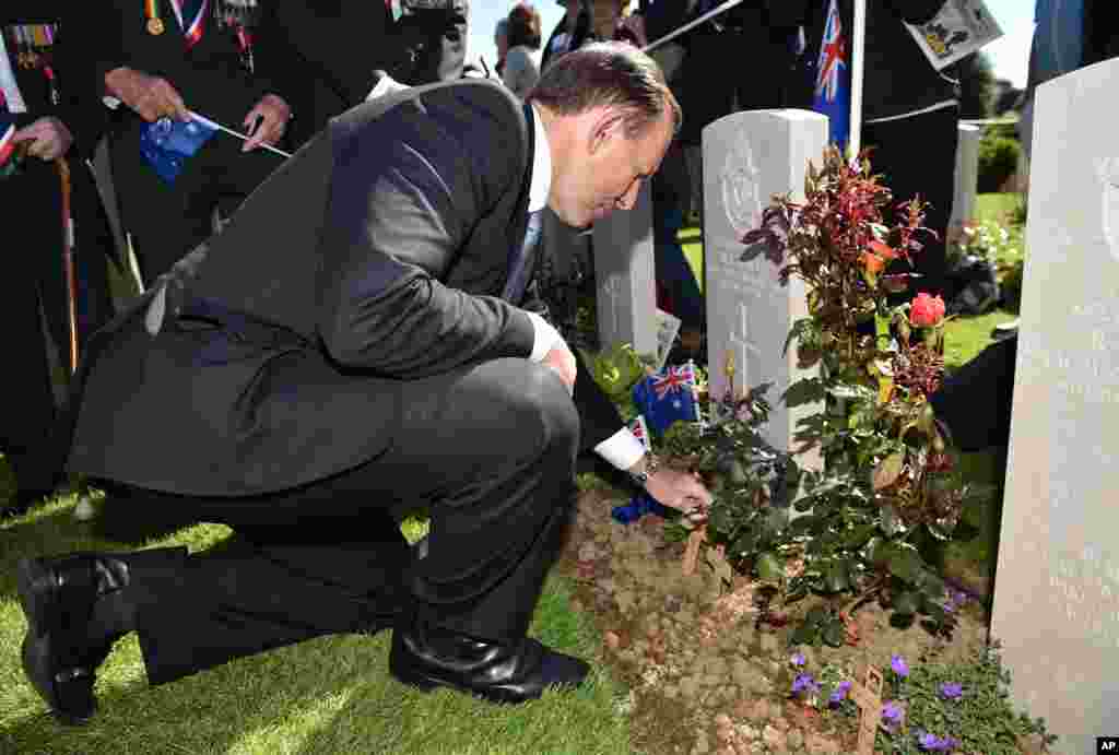 Australia's Prime Minister Tony Abbott places a cross at the British War cemetery in Bayeux, Normandy, France, June 6, 2014.