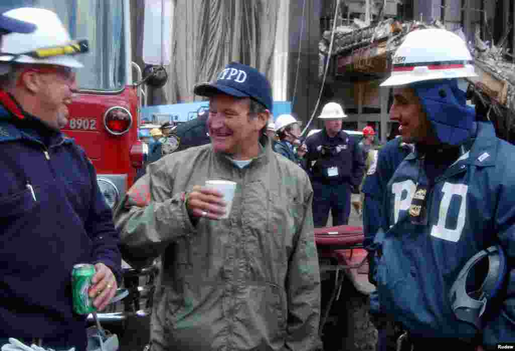 Actor and comedian Robin Williams (center) shares a laugh with rescue workers near the site of the World Trade Center collapse in lower Manhattan, Oct. 17, 2001. Williams spent time with rescue workers and surprised their wives with phone calls.