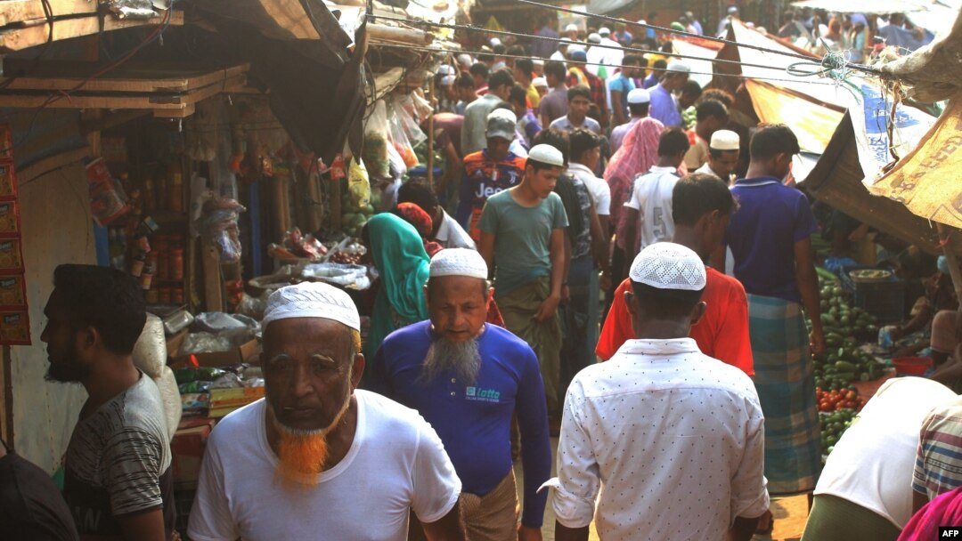 Rohingya refugees walk in market area inside a refugee camp in Ukhia on April 6, 2021 during the second day of weeklong government-imposed lockdown amid an increase of COVID-19 coronavirus cases. (Photo by Miraj KATEB / AFP)