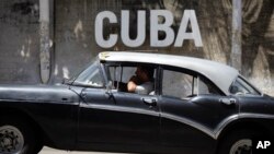 Un taxista cubano pasa frente al Centro Cultural en La Habana.