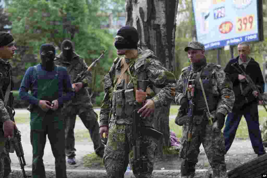 Pro-Russian gunmen listen to instructions from their commander (center) behind barricades in Slovyansk, May 2, 2014.