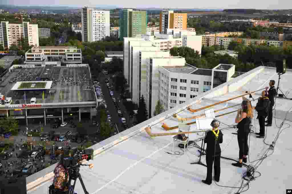 Musicians with alp horns perform on the roof of an apartment block in the Prohlis neighborhood in Dresden, Germany, Sept. 12, 2020. 