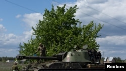 Ukrainian soldiers stand on the top of a tank, amid Russia's invasion of Ukraine, in the frontline city of Lyman, Donetsk region