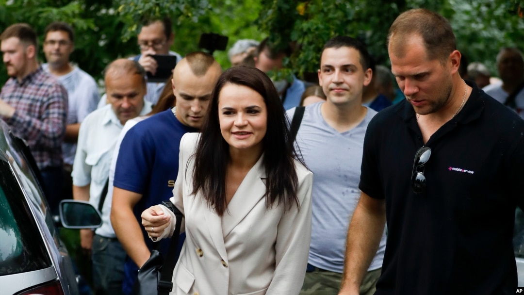 Sviatlana Tsikhanouskaya, candidate for the presidential elections, center, surrounded by her supporters walks after voting at a polling station in Minsk, Belarus, Aug. 9, 2020.