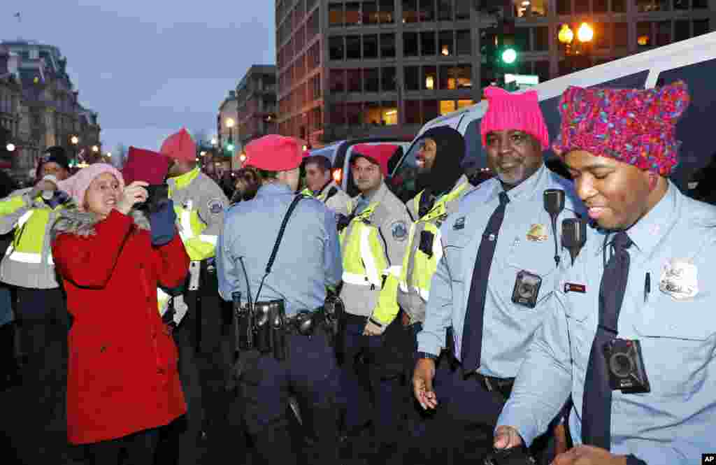 A woman takes a picture of Washington Metropolitan Police Department officers wearing pink hats as marchers fill 17th Street after the Women's March on Washington, Saturday, Jan. 21, 2017 in Washington. (AP Photo/Alex Brandon)