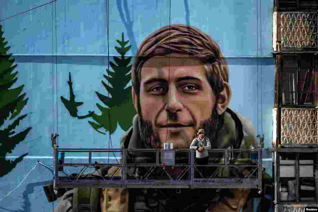 El artista callejero Eugene Gladenko, de 31 años, posa frente a su mural del soldado ucraniano caído en combate, Maksym Bordus. La imagen fue tomada en Kiev, Ucrania, el 8 de octubre de 2024. 