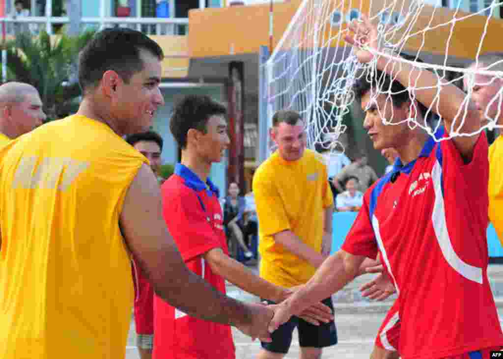 Đà Nẵng, Việt Nam (16/7/2011) Hạ sĩ chuyên viên điện thông tin nội bộ Jose A. Granado Jr., làm việc trên khu trục hạm USS Chung-Hoon (DDG 93), bắt tay với một thủy thủ Việt Nam sau trận đấu bóng chuyền trong dịp Hoạt động Giao lưu Hải quân (NEA) với Việt