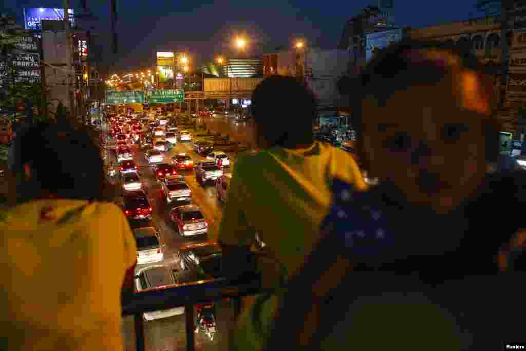 People observe the streets from overhead as anti-government protesters block the road near Government Complex, Bangkok, Jan. 12, 2014. 