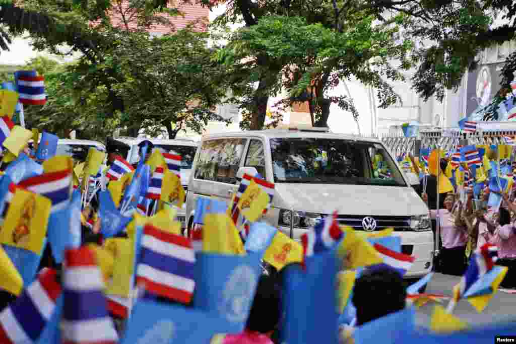 Dân chúng vẫy cờ trong khi đoàn xe của Quốc vương Bhumibol Adulyadej rời bệnh viện Siriraj ở Bangkok, 1/8/13