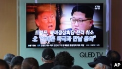 2018年5月25日，人们在韩国首尔火车站观看电视新闻节中，屏幕显示美国总统川普和朝鲜领导人金正。