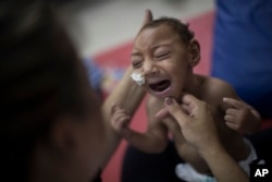 One-year-old Jose Wesley Campos, who was born with microcephaly, cries during a physical treatment at the AACD rehabilitation center in Recife, Brazil, Sept. 28, 2016.