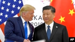 资料照：2019年6月29日，美国总统特朗普和中国国家主席习近平在日本大阪出席G20峰会期间握手。