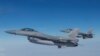 El presidente ucraniano, Volodymyr Zelenskyy, y la primera ministra danesa, Mette Frederiksen, sentados en un avión de combate F-16 en el hangar de la base aérea de Skrydstrup en Vojens, norte de Dinamarca, el 20 de agosto de 2023.