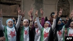 Những người biểu tình chống chế độ ở Syria mặc trang phục hình là cờ cách mạng Syria trong cuộc biểu tình ở Homs