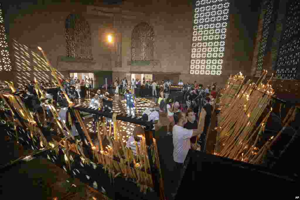 People light candles inside Our Lady of Aparecida Basilica, the temple of Brazil’s patron saint, in Aparecida.