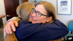 Las ganadoras de Pulitzer del Salt Lake Tribune, Jessica Miller y Erin Alberty, se abrazan al recibir la noticia en su sala de redacción este lunes, 10 de abril de 2017, en Salt Lake City.