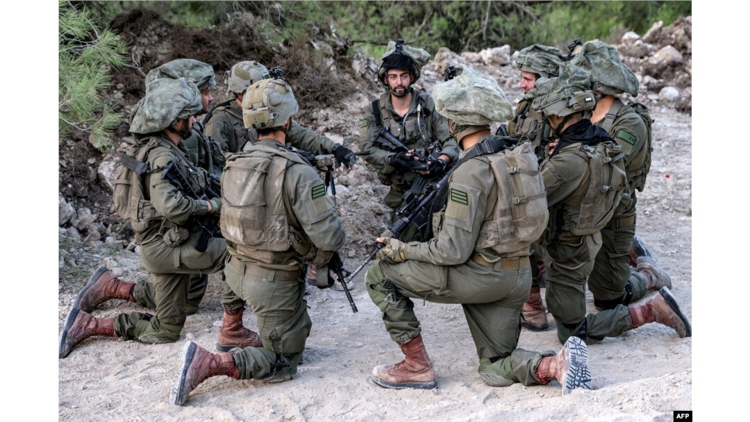 Israeli army soldiers sit kneeling at a position in the upper Galilee region of northern Israel near the border with Lebanon on Nov. 1, 2023, amid increasing cross-border tensions between Hezbollah and Israel.