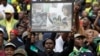 A man holds up a frame showing newspaper clippings of anti-apartheid activist Winnie Madikizela-Mandela during her memorial service at Orlando, Stadium, in Soweto, Apr. 11, 2018. 