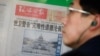 北京街头一个报刊亭中展示环球时报的头版头条，照片为美国总统拜登就职典礼时的国会大厦全景。（2021年1月21日） 