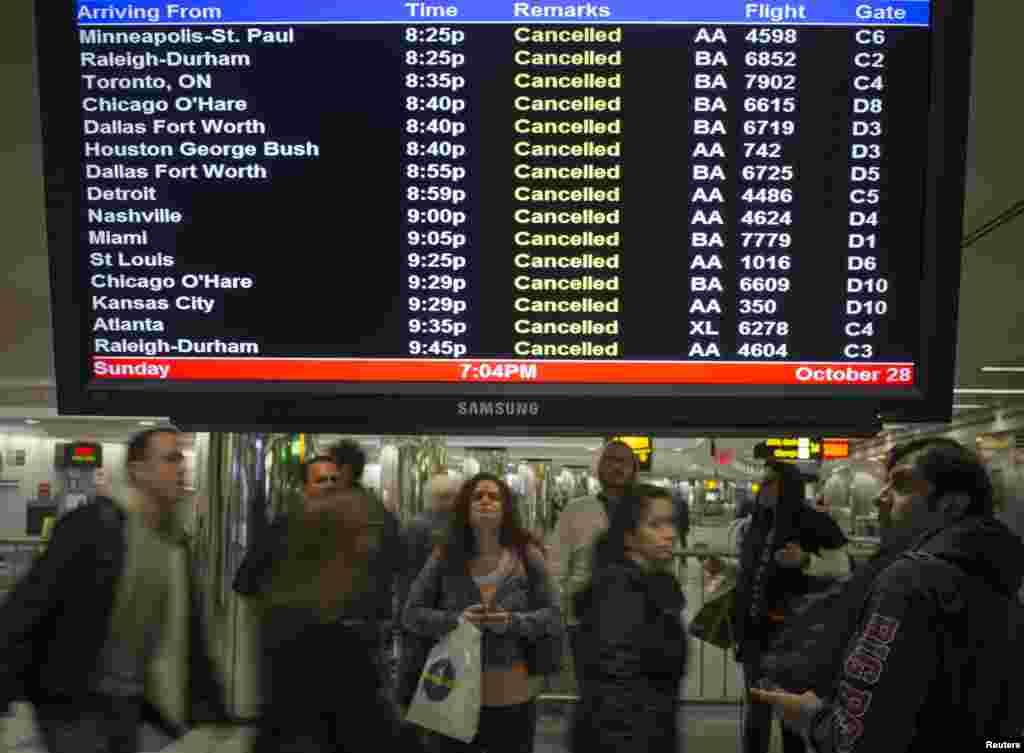 Hành khách đứng xem màn hình các chuyến bay bị hủy tại Phi trường LaGuardia ở New York, ngày 28/10/2012.