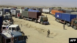 Binh sĩ Pakistan canh gác bên cạnh các xe tại chở tiếp liệu tại khu vực biên giới giáp với Afghanistan