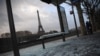 Un autobús dañado detenido en París y al fondo la torre Eiffel, un día después de protestas de los "chalecos amarillos", en el cuarto fin de semana de disturbios. Domingo, 9 de diciembre de 2018. 