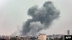 从加沙地带南部城市拉法看到的在以色列轰击加沙地带中部城市汗尤尼斯时从汗尤尼斯冒起的浓烟。(2024年3月29日)