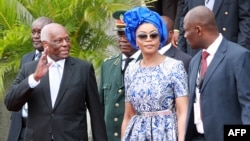 Rais wa zamani wa Angola Eduardo Dos Santos aliyeinua mkono juu kwenye picha ya zamani.
