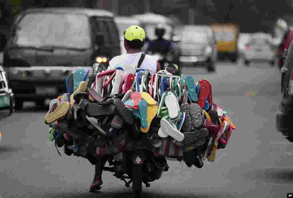 A man peddles rubber flip-flops on his motorcycle in Manila, Philippines.
